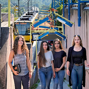 Sozialarbeiterin trifft Mädchen beim Streetwork an der Stadtbahnhaltestelle.